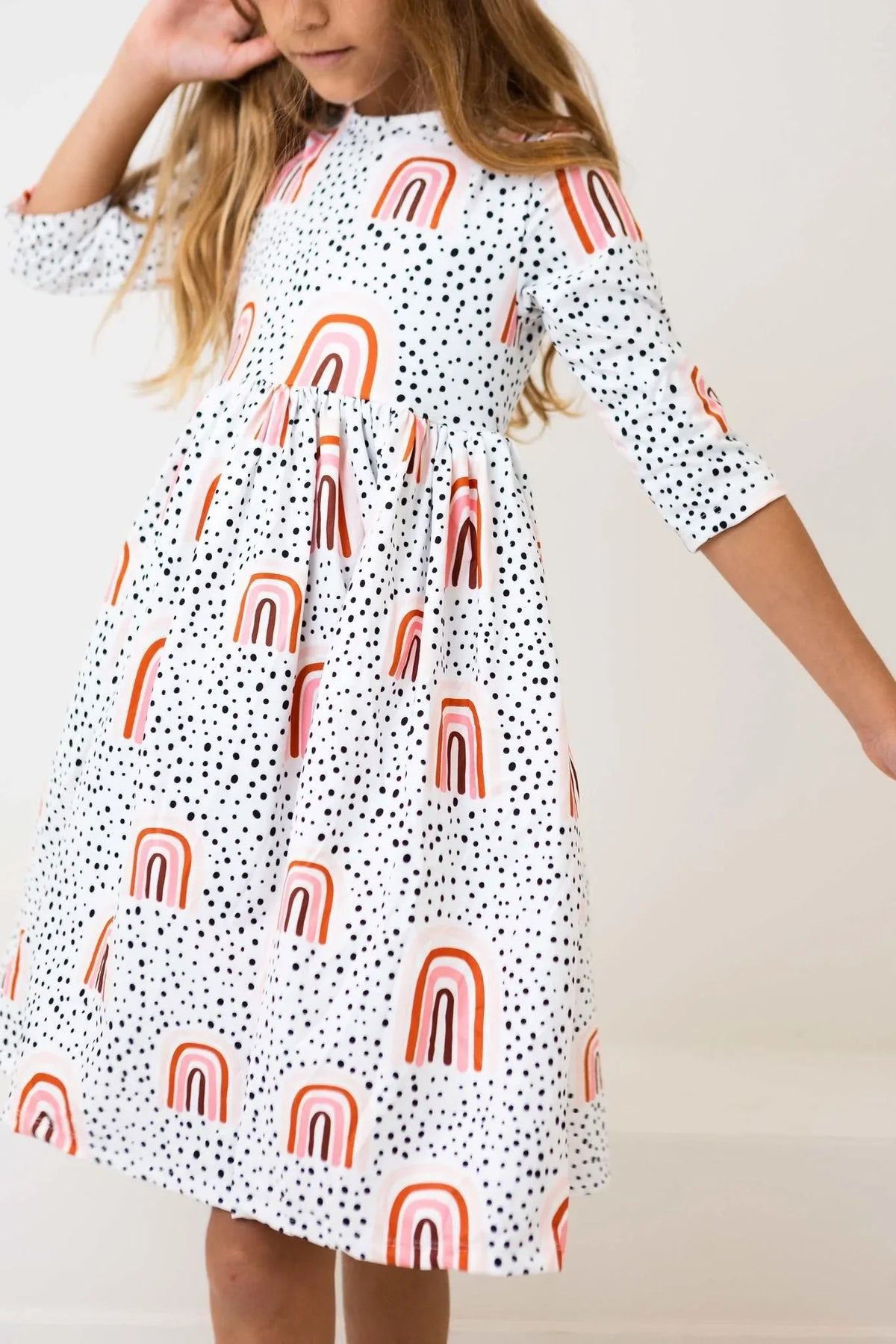 Girls peach rainbow twirl dress with 3/4 sleeves and polka dot pattern by Mila & Rose