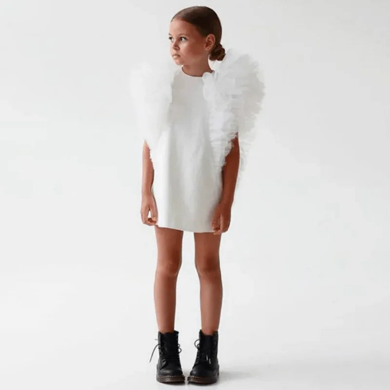 girls white party dress with large ruffled shoulders, toddler size, paired with black boots