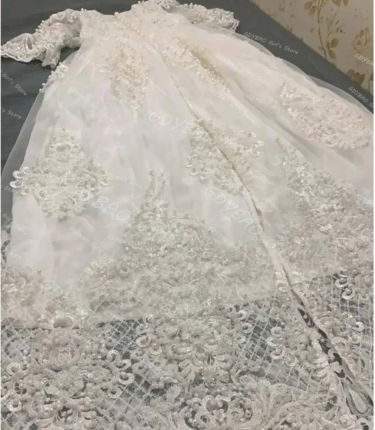 White pearl lace christening gown for babies and toddlers laid flat showing intricate lace details