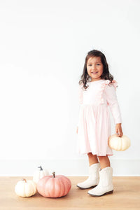 Girls petal pink long sleeve dress with twirl ruffle detail, toddler size, styled with white boots