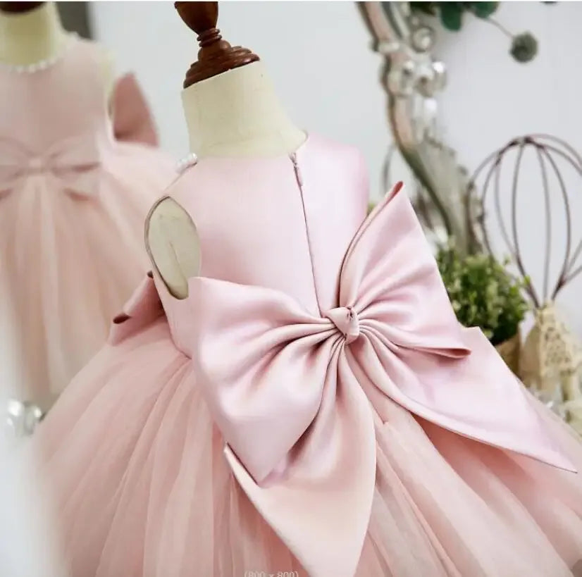 Pink baptism dress for girls with large bow detail and tulle skirt for toddlers