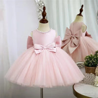 pink baptism dress for girls with sleeveless bodice, pearl neckline, and large bow detail