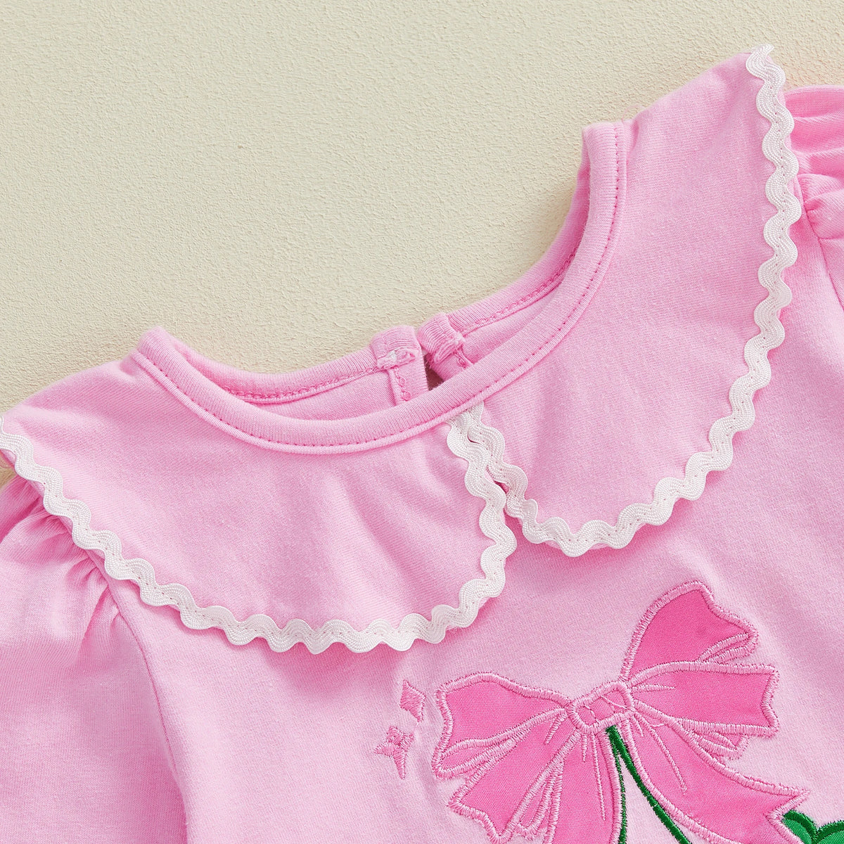 Soft cotton pink embroidered baby bubble romper with scalloped collar and bow detail