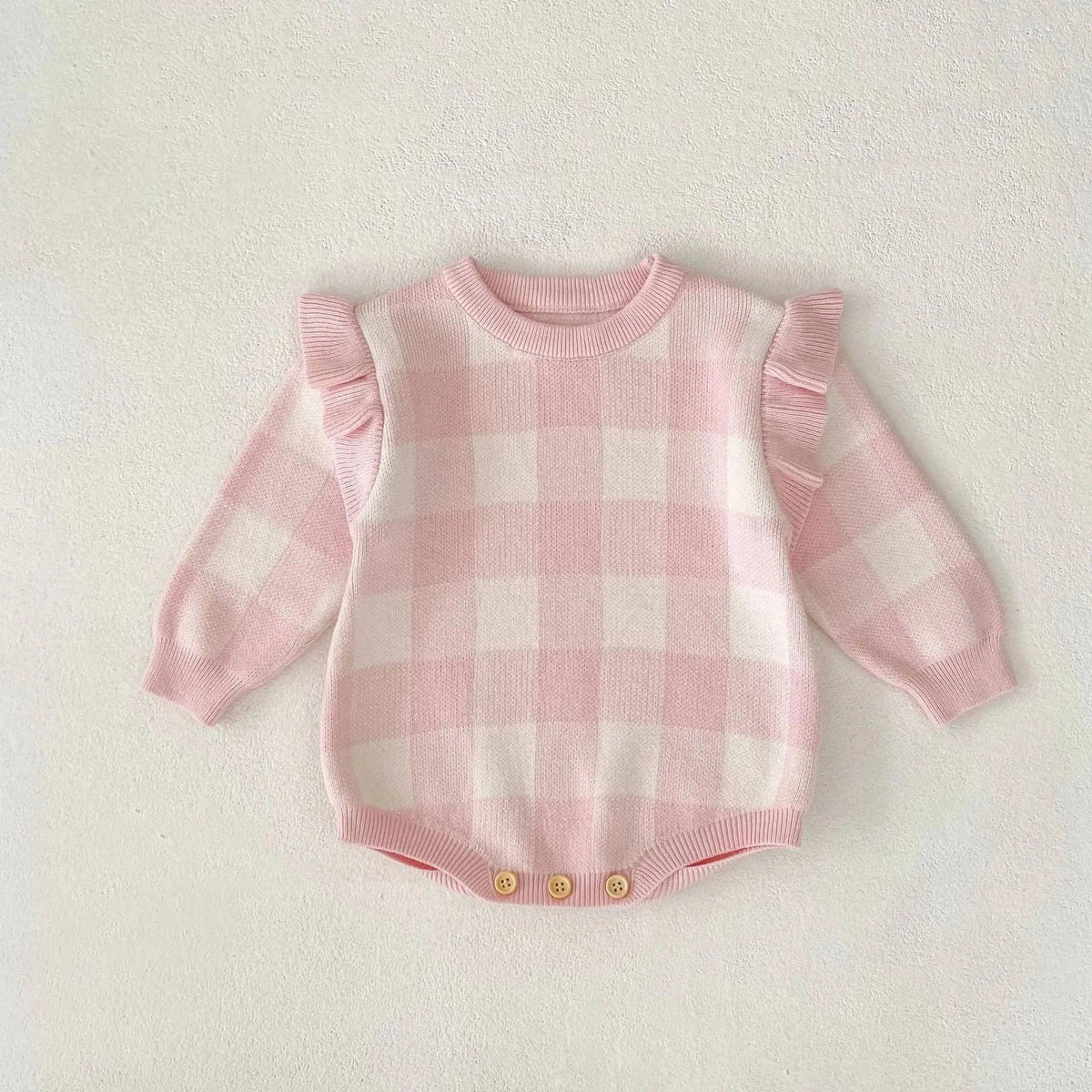 pink plaid baby romper for infants with long sleeves and ruffle details on shoulders