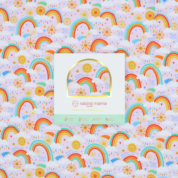 Packaging of The Forever Swaddle Blanket - Here Comes the Sunshine (Pink) showcasing the vibrant rainbow design and brand logo of Raising Mama, highlighting its cheerful and nurturing theme.