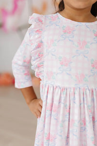 Girls pink ruffle twirl dress for girls by Mila & Rose with 3/4 sleeves and floral bow print