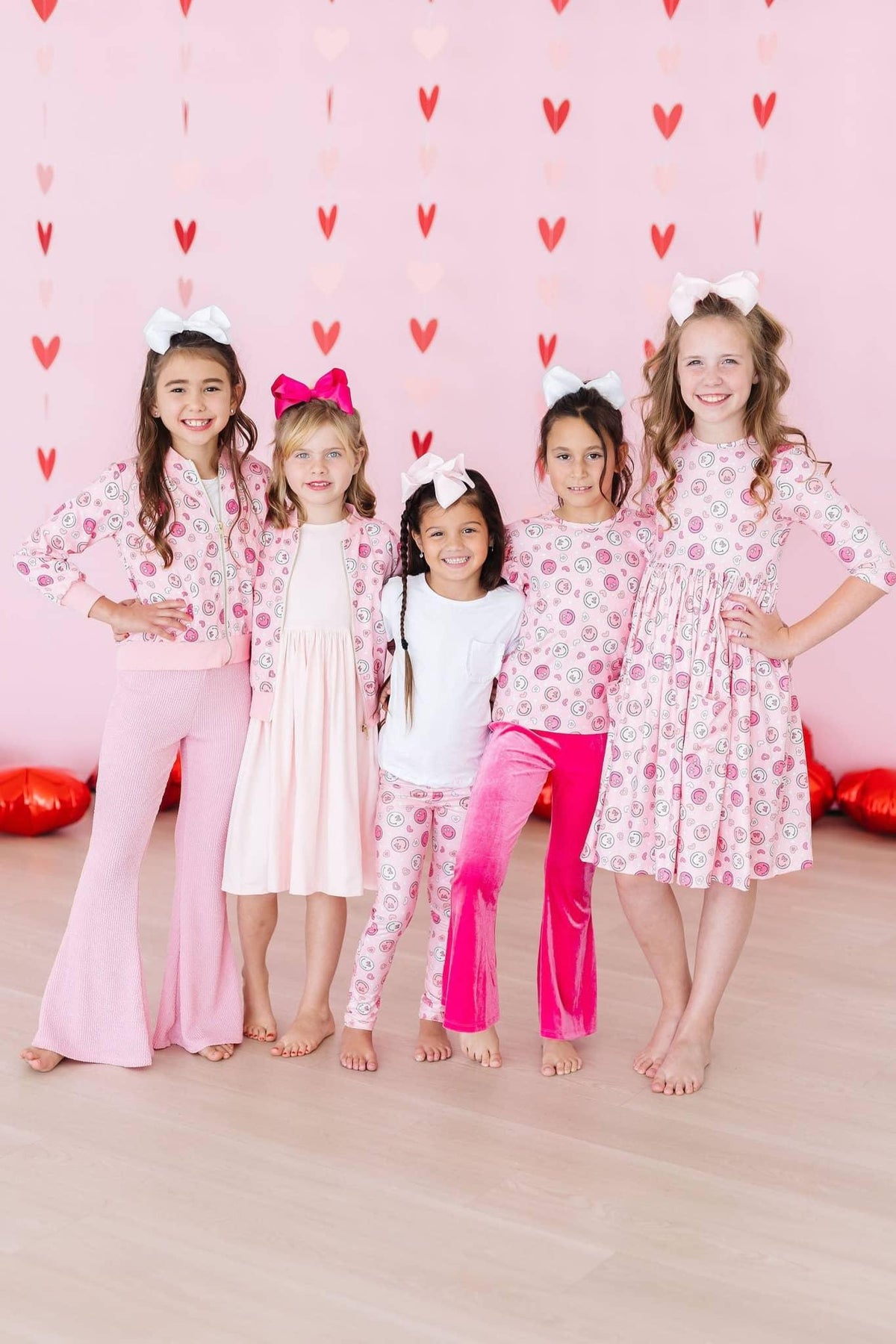 Girls pink Mila & Rose satin jacket with heart pattern, long sleeve, worn by children in matching pink outfits