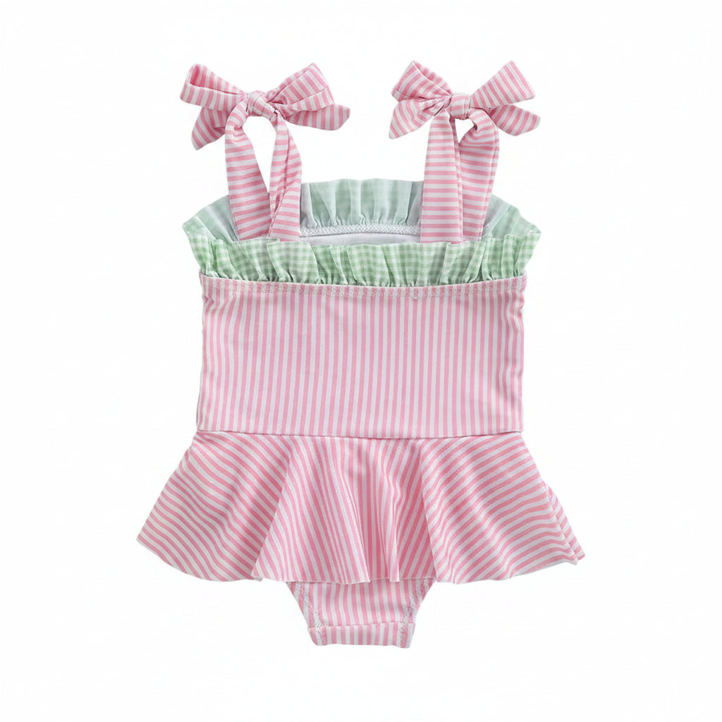 pink seersucker baby swimsuit with green ruffle detail and bow straps for infants