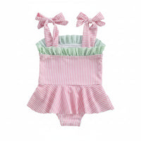 pink seersucker baby swimsuit with green ruffle detail and bow straps for infants