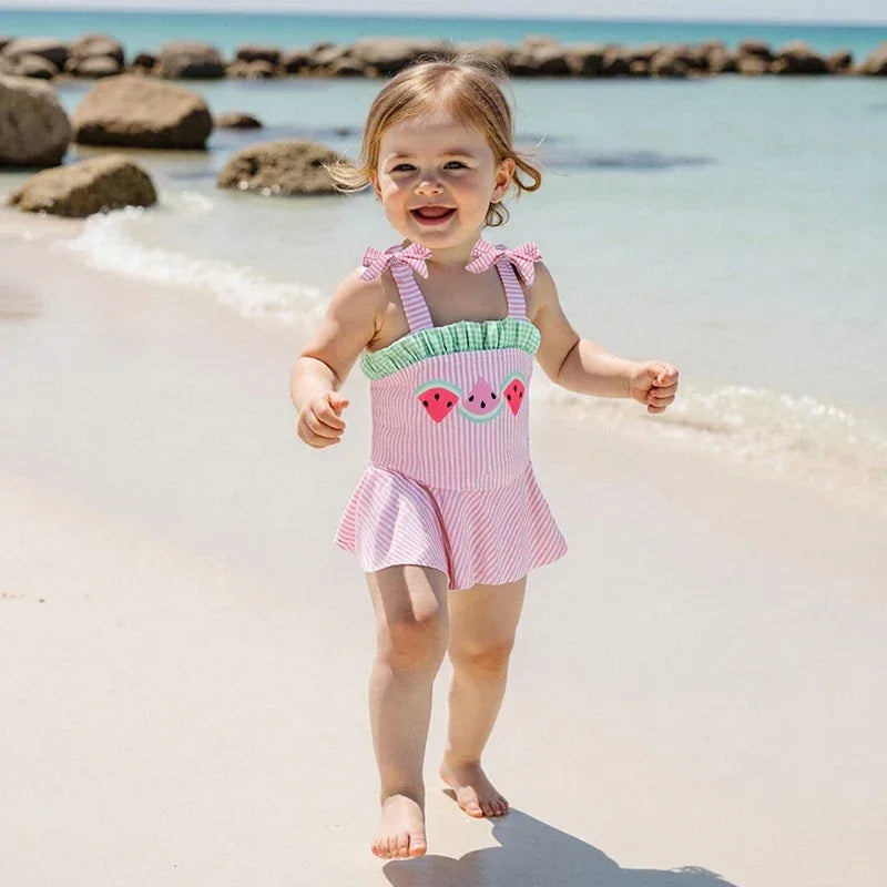 pink seersucker baby swimsuit for toddler girls with watermelon print and ruffle skirt