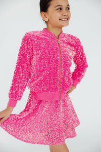 girl wearing pink sequin jacket for girls with matching skirt smiling and posing