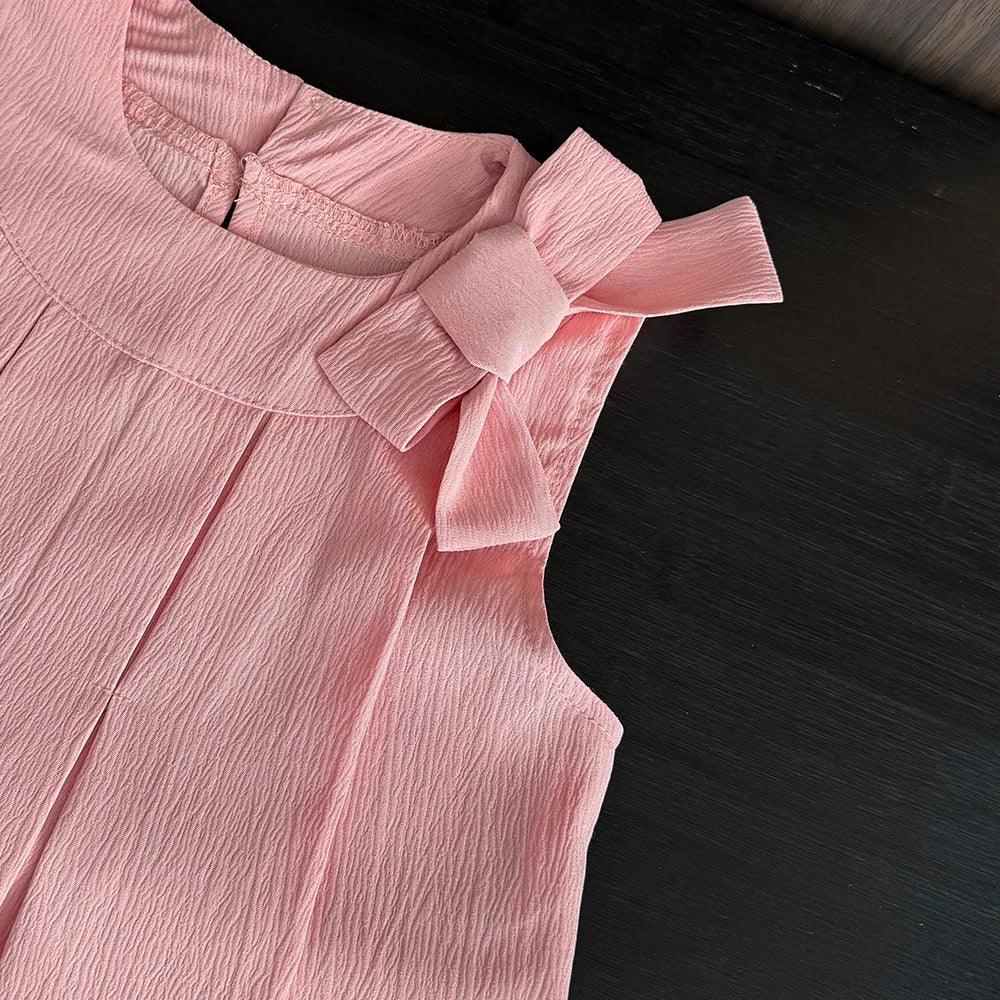 baby pink shorts set with textured fabric and large bow detail on shoulder