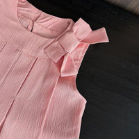baby pink shorts set with textured fabric and large bow detail on shoulder