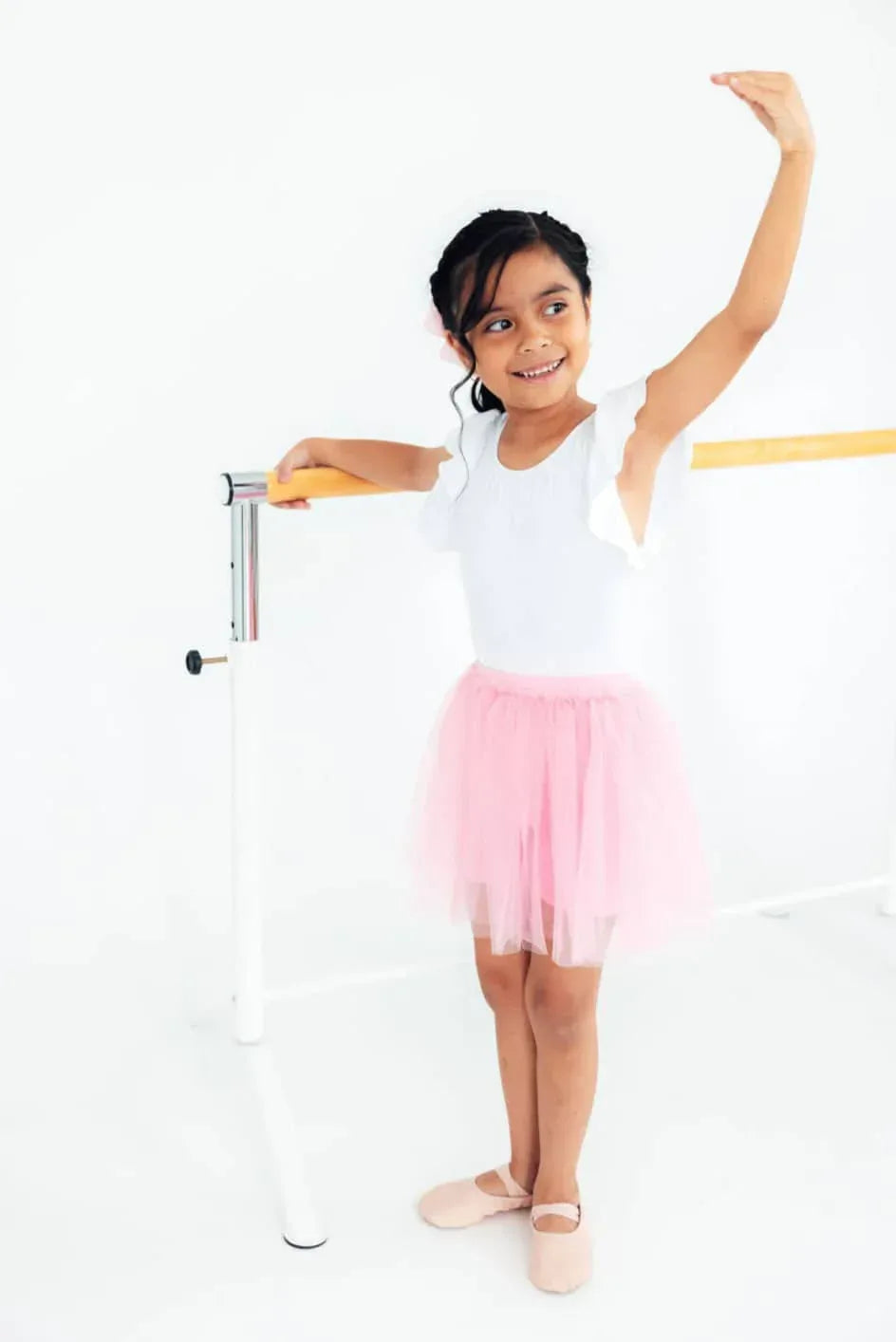 Young girl wearing pink tutu shorts for girls practicing ballet at barre