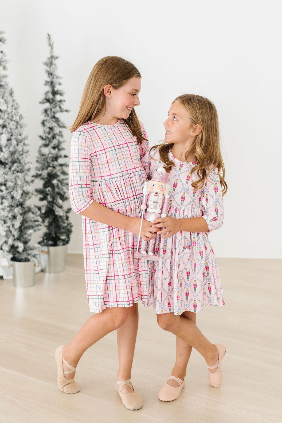 Two girls wearing pocket twirl dress for girls in pink and white patterns with 3/4 sleeves