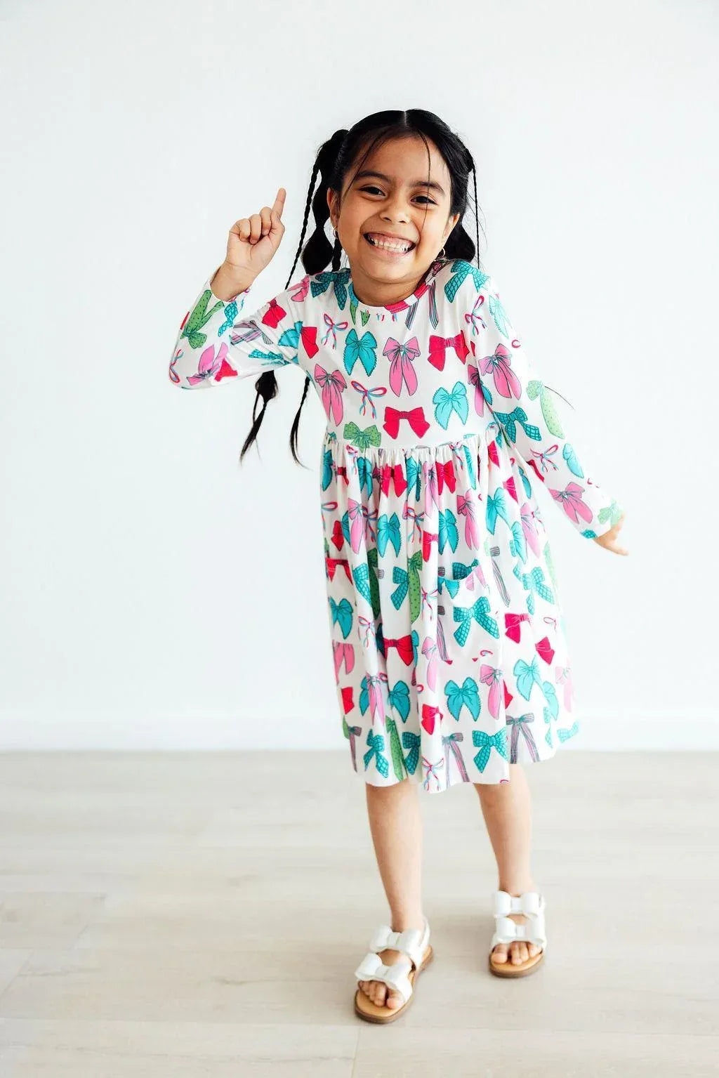 Girls long sleeve white pocket twirl dress for girls with colorful bow pattern