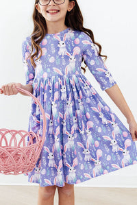 girl wearing purple pocket twirl dress with bunny print holding pink basket