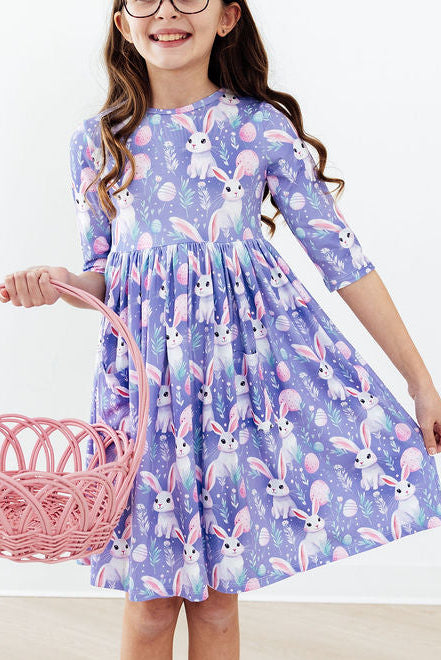 girl wearing purple pocket twirl dress with bunny print holding pink basket
