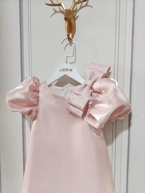princess pink party dress for little girls with puff sleeves and large bow detail