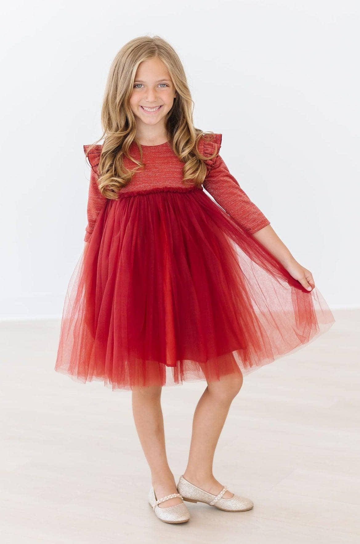 Young girl wearing red pumpkin spice tutu dress for girls twirling with a smile