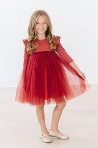 Young girl wearing red pumpkin spice tutu dress for girls twirling with a smile
