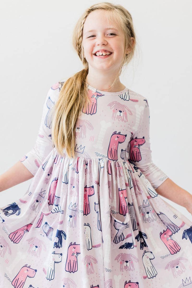 young girl wearing pink puppy party dress for girls twirl pocket dress smiling and spinning
