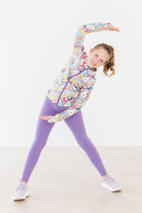 Girls purple leggings by Mila & Rose activewear with high waist, worn by a girl stretching