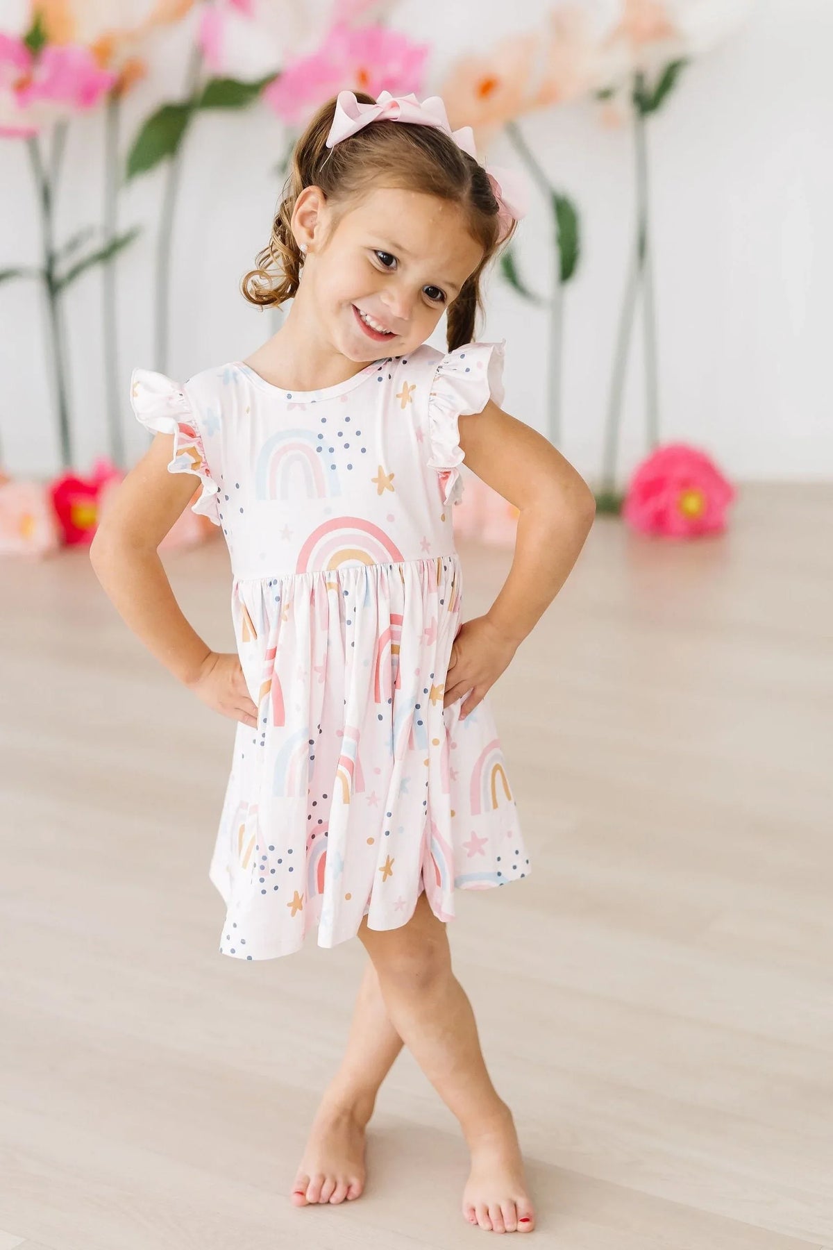 Girls white twirl dress with rainbow flutter sleeves and playful rainbow print for toddlers
