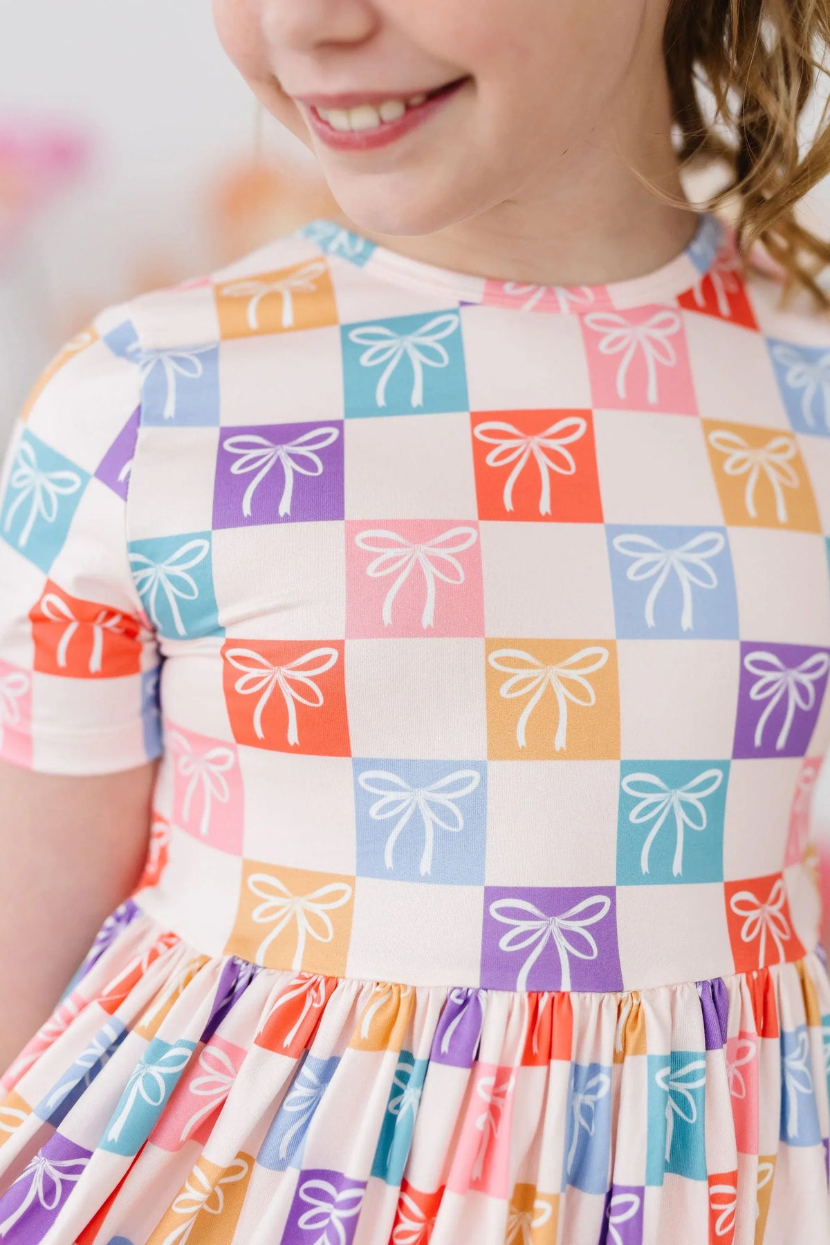 Girls rainbow twirl dress for girls by Mila & Rose with colorful bow print and short sleeves