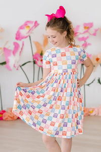 Girls short sleeve rainbow twirl dress for girls with colorful square pattern and gathered waist