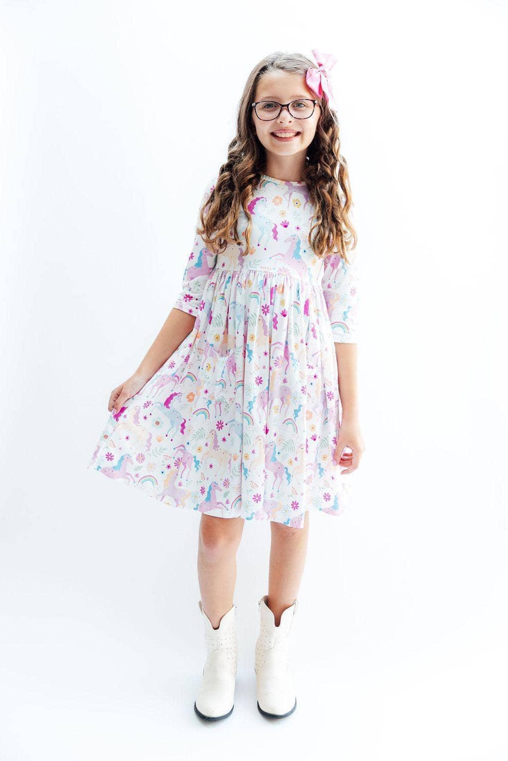 Young girl wearing rainbow twirl dress for girls with sleeves standing and smiling