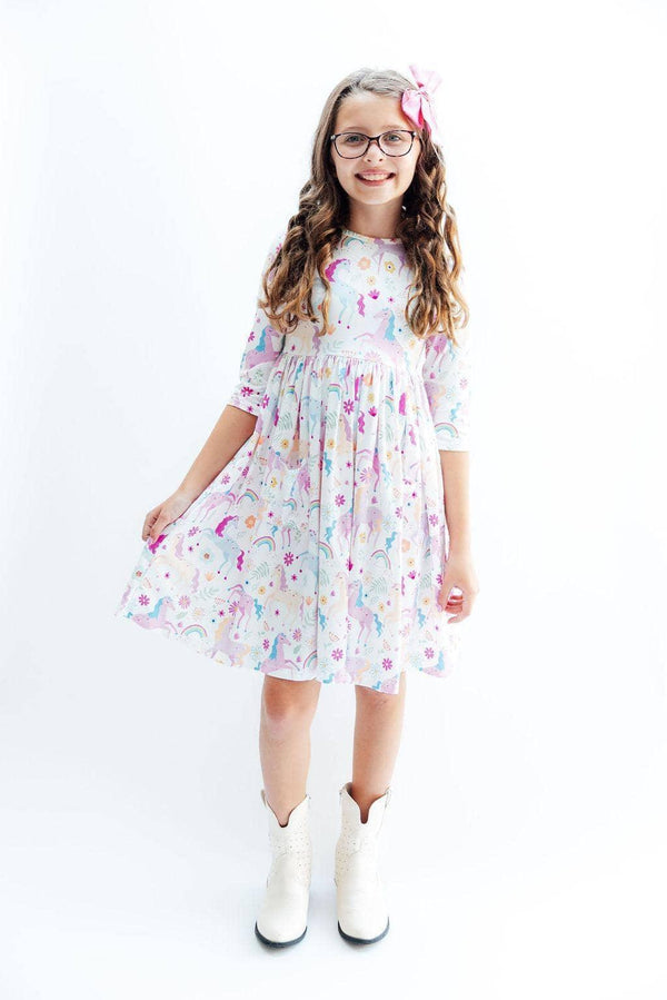 Young girl wearing rainbow twirl dress for girls with sleeves standing and smiling