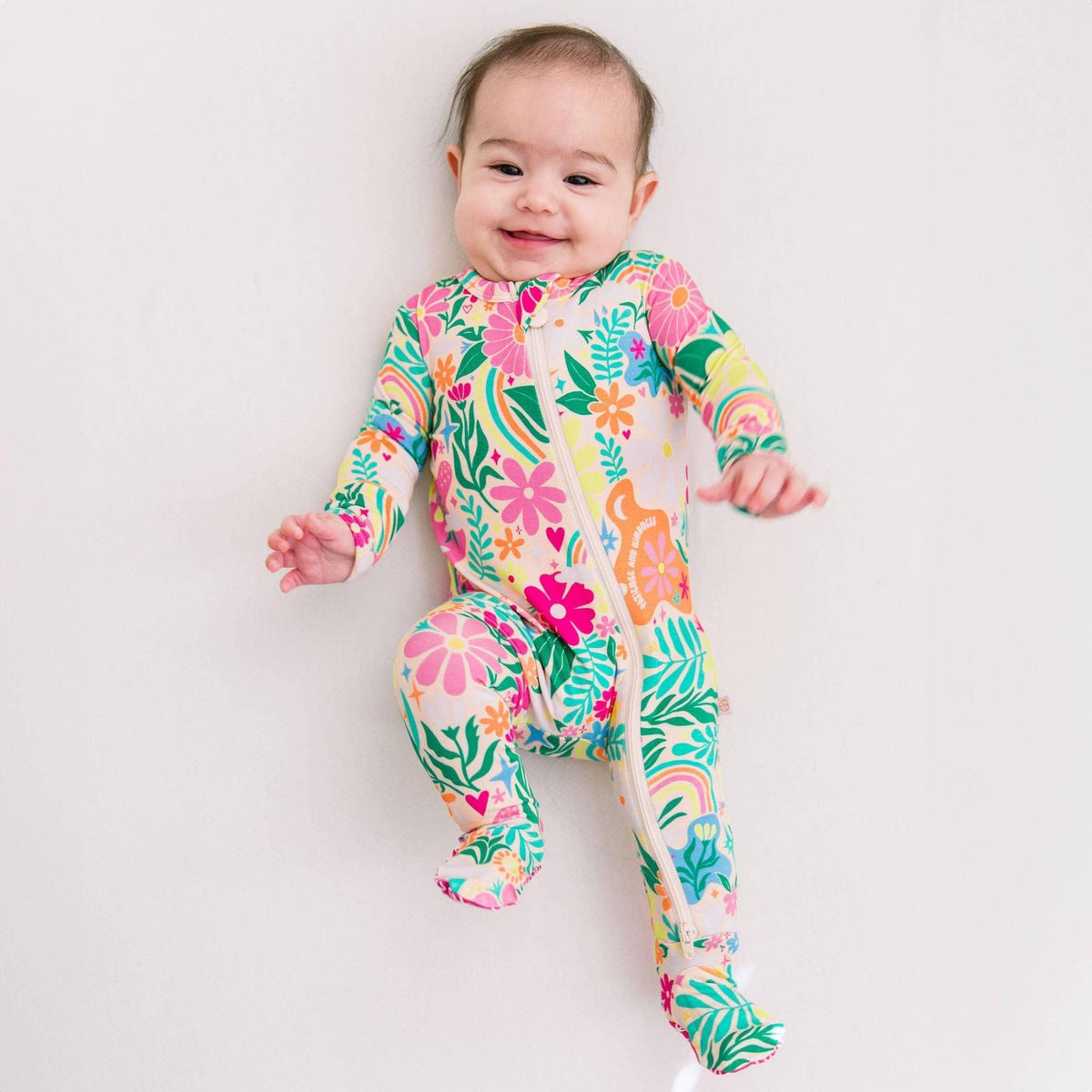 Raising Mama Rainbow Daisy Baby Footie - Colorful Floral Baby Romper - The Palm Beach Baby