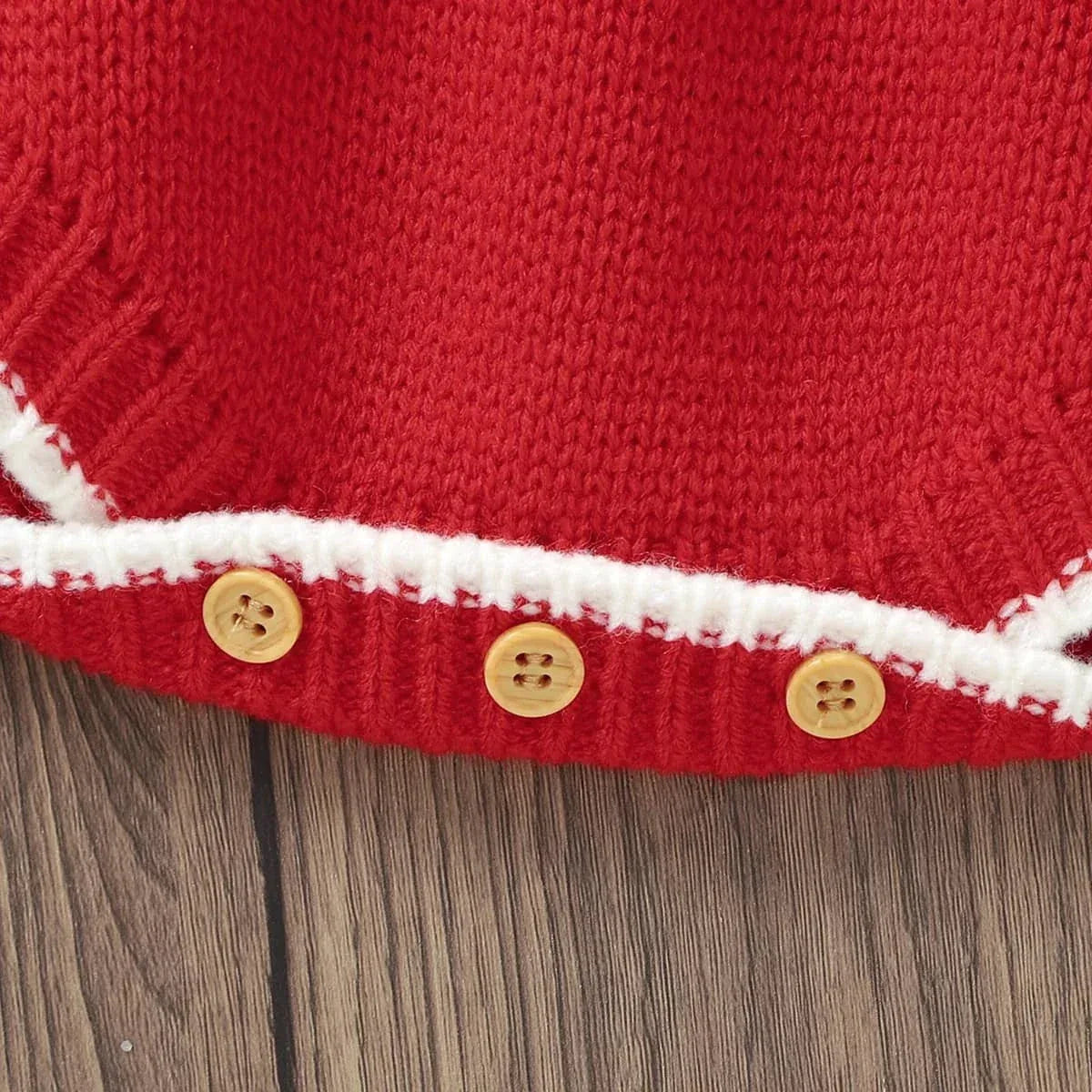 close-up of red baby bubble romper knit fabric with white trim and wooden buttons for infants