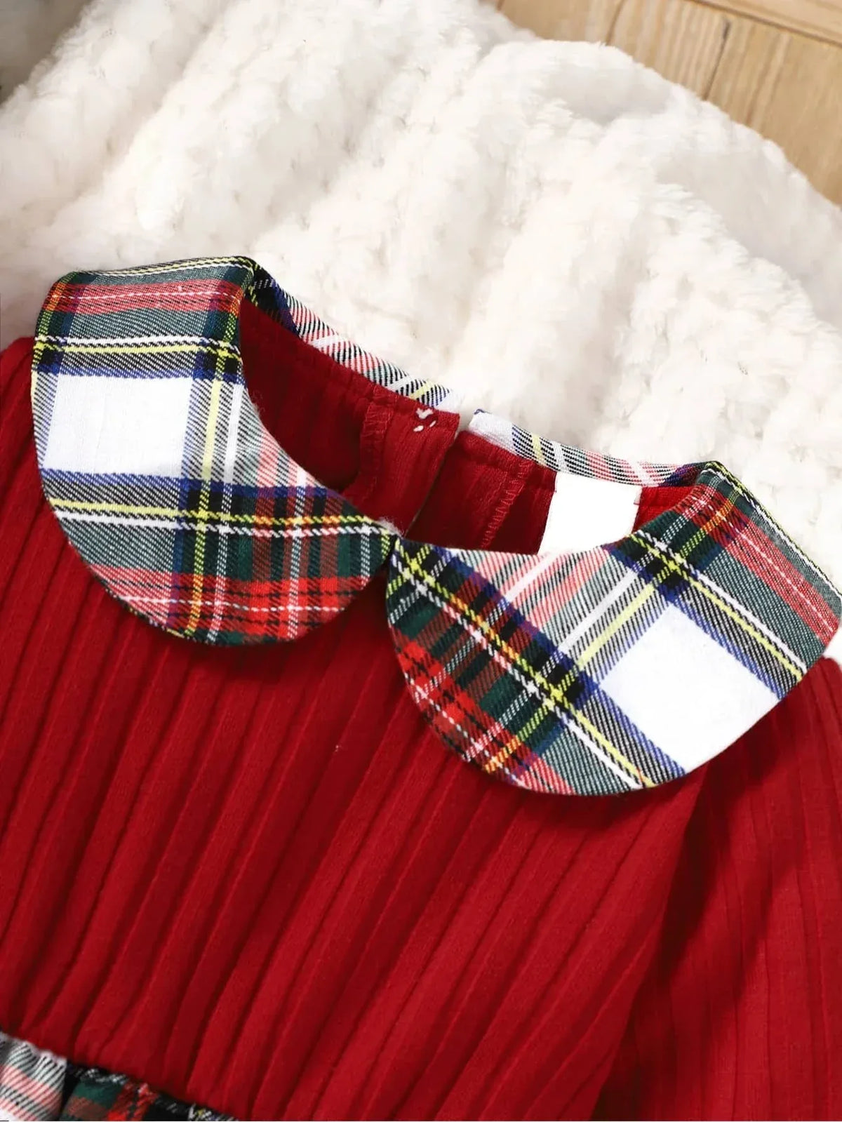Close-up of red plaid girls dress collar with pleated red fabric for toddlers