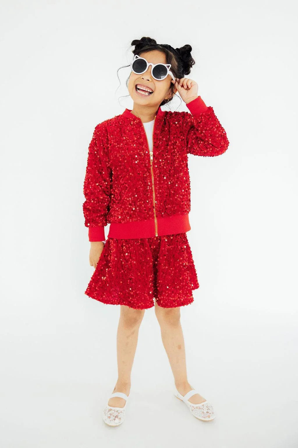 Red sequin jacket for girls, long sleeve with zipper, worn by a smiling child