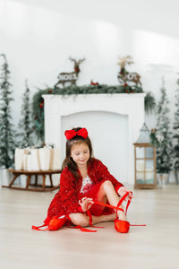 Red sequin jacket for girls, long sleeve, worn by young girl sitting indoors tying red ballet shoes