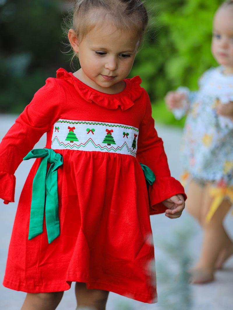 Front view of red festive dress showing ruffled bell sleeves and white smocked bodice