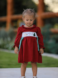Red Christmas smocking embroidered girls dress with green plaid bow and festive dog and tree design.