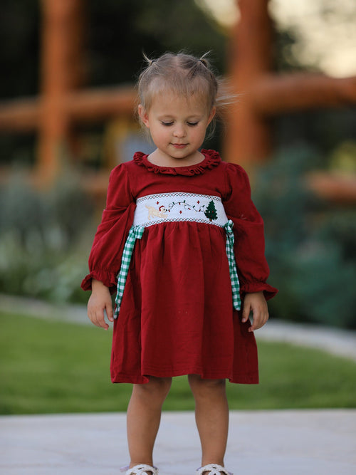 Red Christmas smocking embroidered girls dress with green plaid bow and festive dog and tree design.