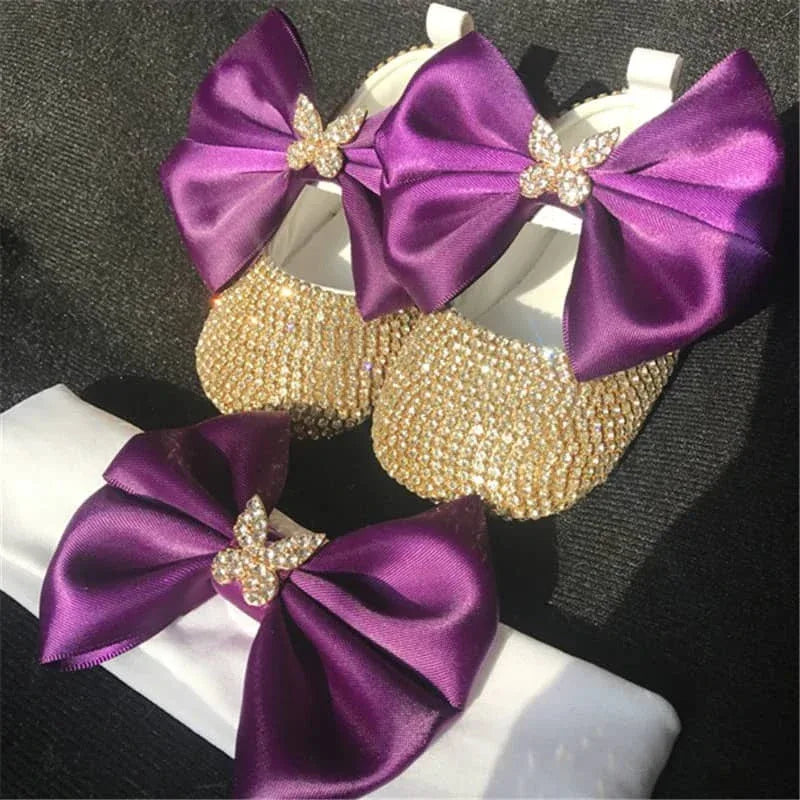 gold rhinestone first walker baby shoes with large purple bows and matching purple bow headband for infants