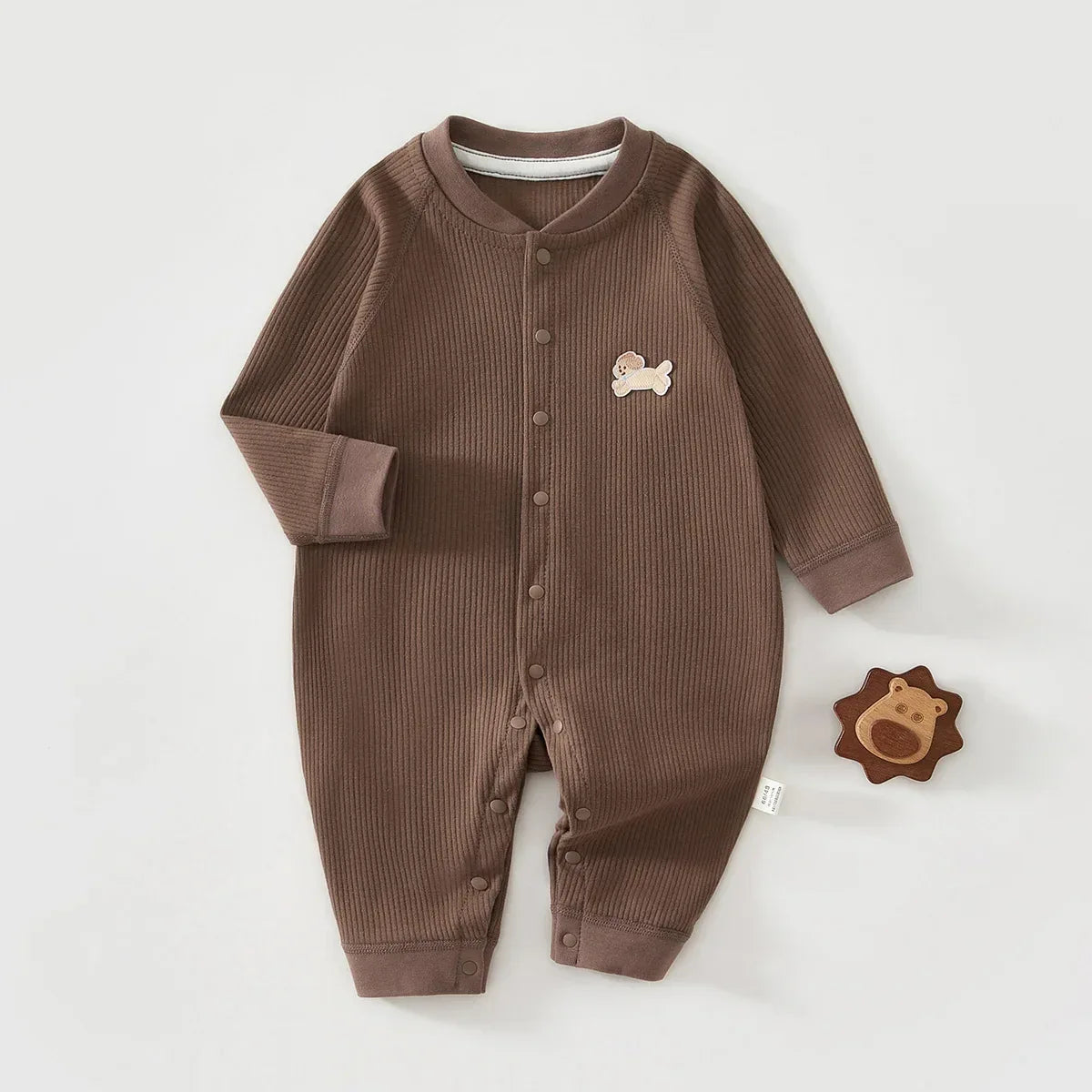 Brown ribbed knit baby romper made of soft cotton with long sleeves and snap buttons