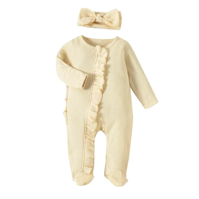 cream ribbed knit baby romper with headbow for newborns laid flat with ruffle detail
