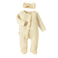 cream ribbed knit baby romper with headbow for newborns laid flat with ruffle detail
