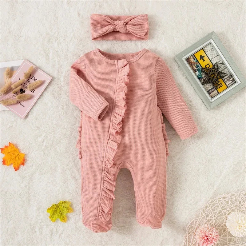 pink ribbed knit baby romper with headbow for infants laid flat on white surface