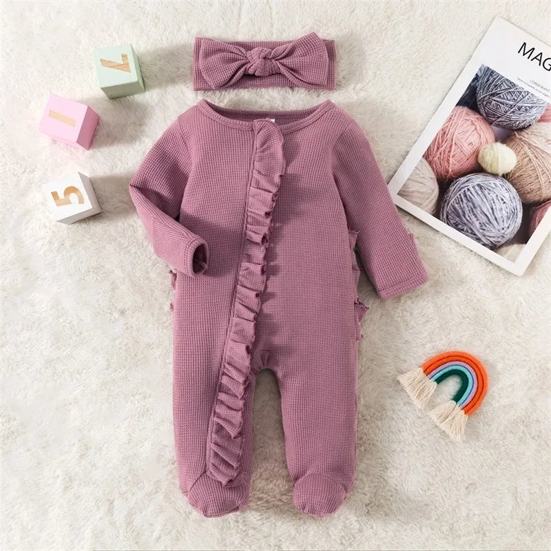 Mauve ribbed knit baby romper with headbow for infants laid flat on white rug with colorful toys