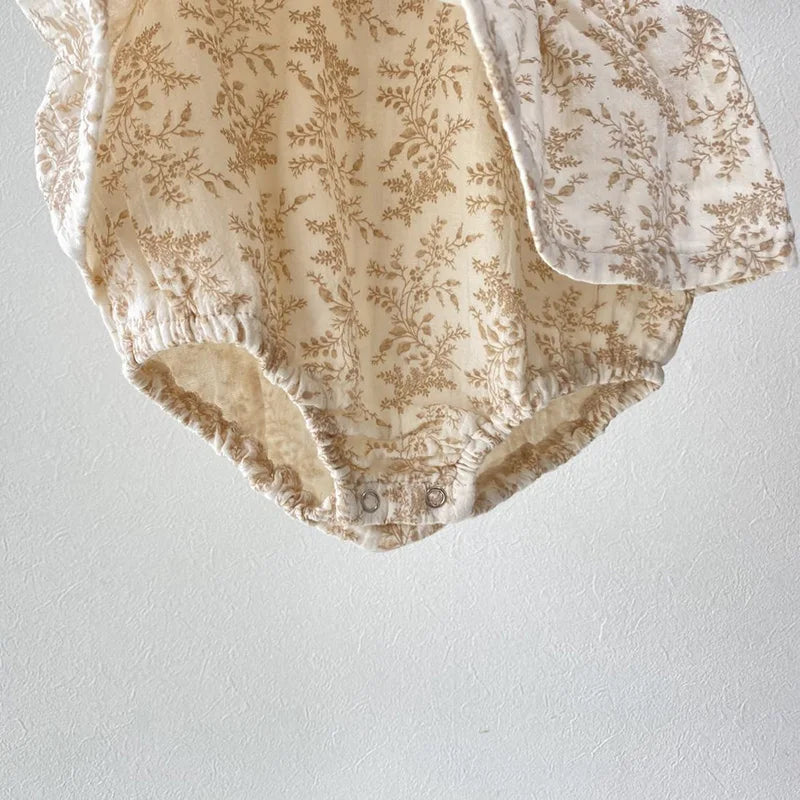 Beige floral print romper for babies with long sleeves and snap closures at the bottom