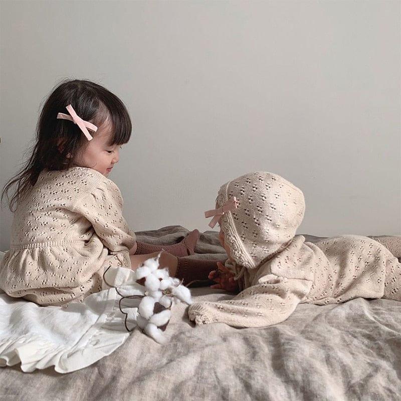 Beige knit romper for babies and toddlers with eyelet pattern and soft fabric details