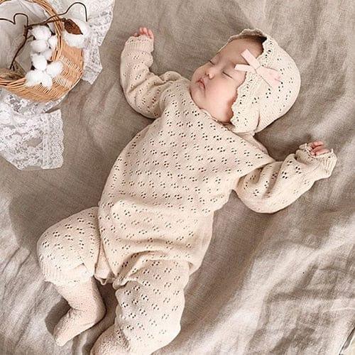 Beige knitted baby romper with matching bonnet and pink bow for newborns