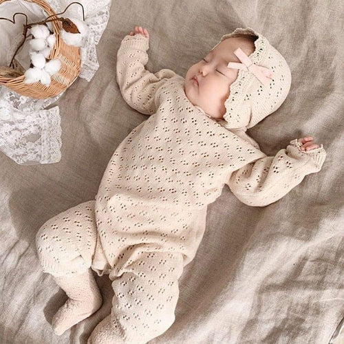 Beige newborn baby romper with knitted eyelet pattern and matching bonnet with pink bow